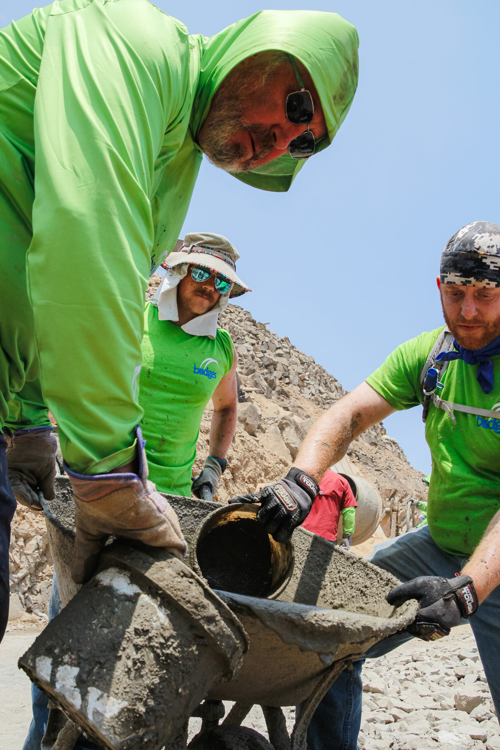 Bridges volunteers mixing and pouring concrete together